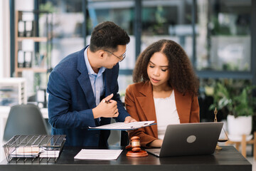 Business and lawyers discussing contract papers. with brass scale on justice and law..