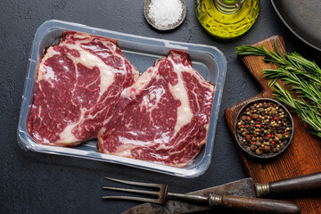 Raw ribeye steaks with savory spices