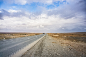 Automobile asphalt road highway through the desert in Karakalpakstan