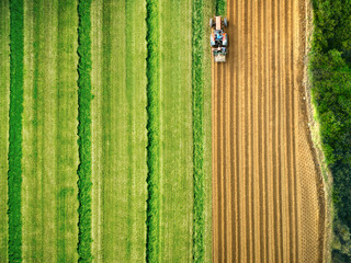 Tractor mowing agricultural separate field, aerial drone view 