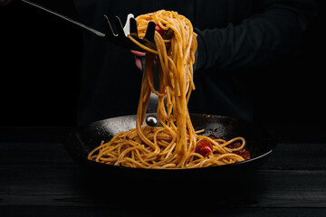 A man prepares pasta with spaghetti, tomatoes and spices. - 675249251