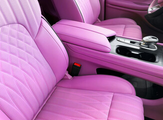 Modern luxury car pink leather interior. Part of pink leather car seat details with white...
