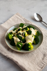 Yummy Cheesy Steamed Broccoli on a Plate, side view.