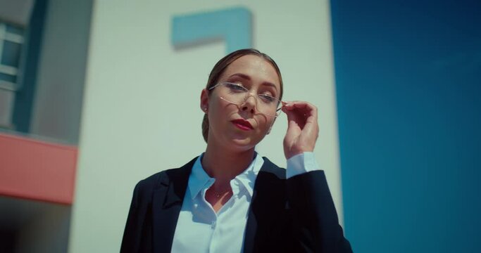 Portrait of strict teacher woman with glasses on face standing outdoors and talking, 4K, Prores