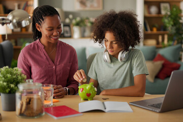 Mother and her teenage son saving money in piggy bank