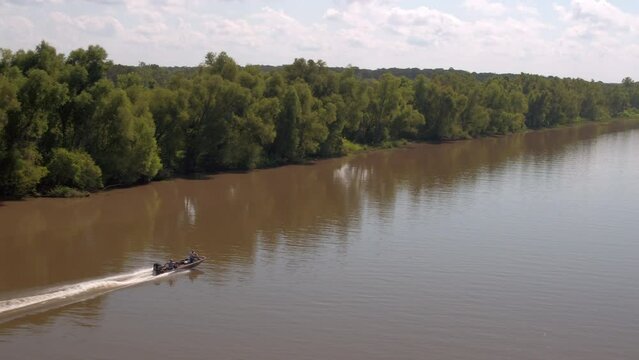 Aerial Shot Of Motorboat Moving On River By Green Trees, Drone Flying Forward During Sunny Day - Bayou, Louisiana