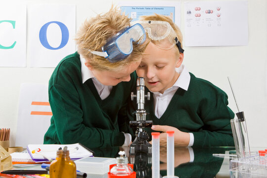 Two boys looking in a microscope
