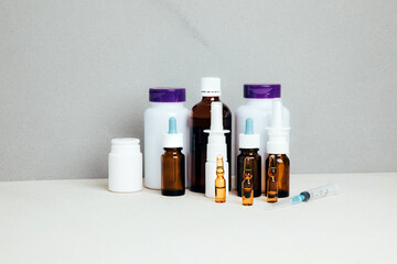 A set of medicines for treatment in bottles and tablets in transparent plates on a light...