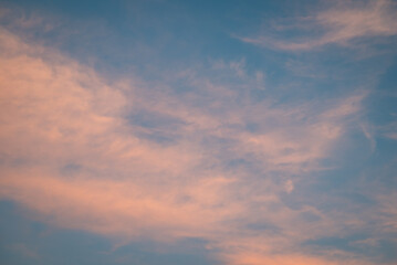 Naklejka na ściany i meble Light clouds in sky after sunset. Calm evening with clouds illuminated by last rays of sun