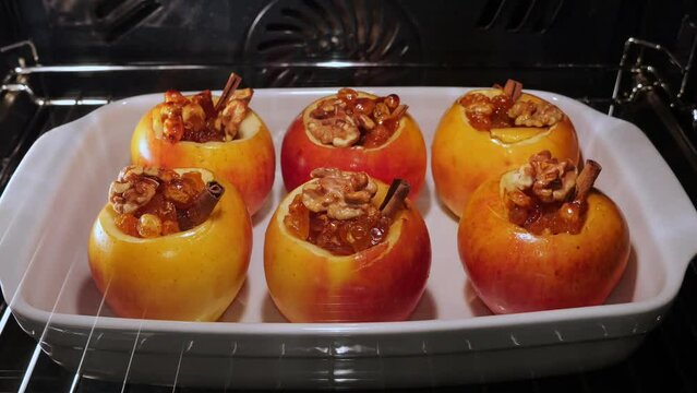 Apples with raisins, cinnamon and honey baked in the oven cooking process. Time lapse