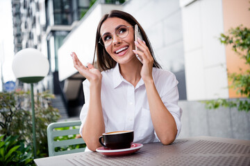 Fototapeta premium Photo of attractive peaceful girl toothy smile chatting telephone drink coffee fresh air cafe outside