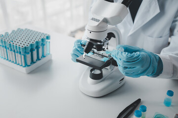 chemist is doing an experiment in the laboratory, A scientist is using a microscope to analyze the...