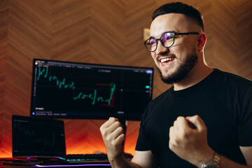 Man trader sitting by his coputer working on exchange market