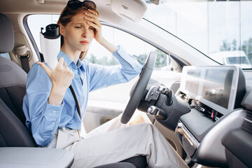 Woman sitting happy in her wlwctric car
