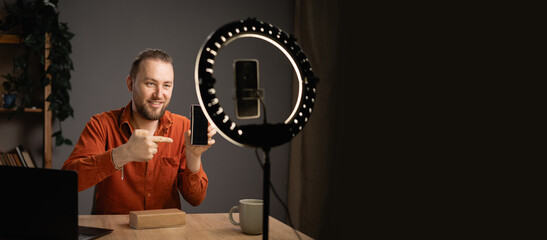 Influencer recording unboxing video modern smartphone for his vlog. Creative content creator.