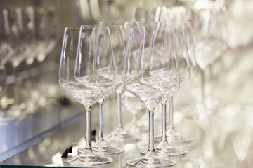 Clean and empty long stemmed elegant wine glasses on storefront, close up. 