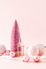 bottle of women's perfume or cosmetic spray on the background of a pink decorative Christmas tree...
