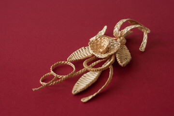 Decoration of straw on a red background. Branch with flowers. Decor