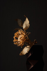 Flower made of straw on a dark background. The flower is illuminated by the sun. Small depth of field. 