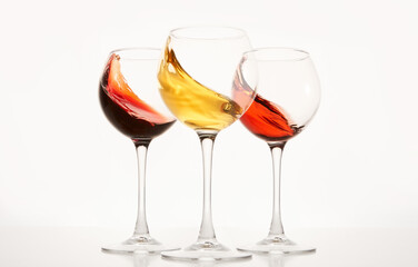 Rose, white, red wines splashes in stemware.