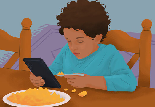 Messy, distracted boy eating macaroni and cheese and using smart phone at dining table
