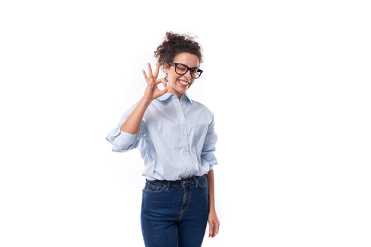 beautiful young stylish caucasian office worker woman with curly hair wears glasses for image and light blue shirt