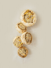 Top quality stuffed mushrooms cups on a cooking paper. High quality product with breadcrumbs,...