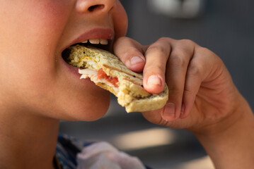 Teenage boy eating snacks close-up. Snack, sweets, street food. Intermediate meal. Mouth with...
