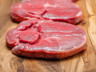 Fresh juicy boneless lamb steak on a wooden board. Premium meat product for cooking. High quality meat cut. Food chain.