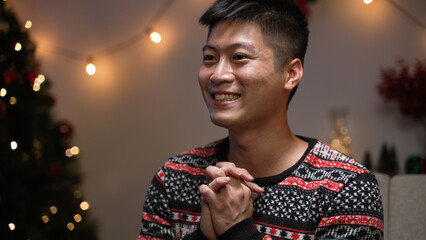 excited man looking and pointing at empty space while taking to friend with crossed fingers, feeling confident about present he prepares at gift exchange party