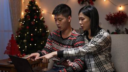 asian couple making online payment with credit card while they are shopping for Christmas gifts on...