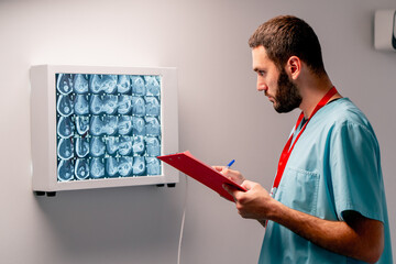 The radiologist carefully studies the MRI image on special board describes what he saw and writes...