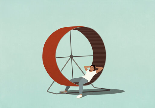 Man relaxing with hands behind head on hamster wheel
