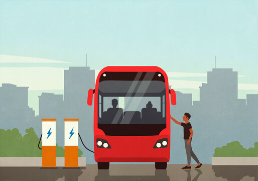 Man boarding electric bus at charging station in city

