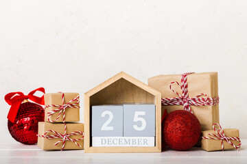 25 december. Christmas composition on colored background with a wooden calendar, with a gift box,...
