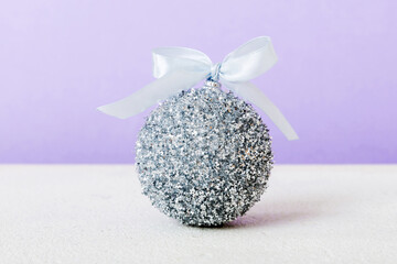 Christmas ball on colored background. decoration bauble with ribbon bow with copy space