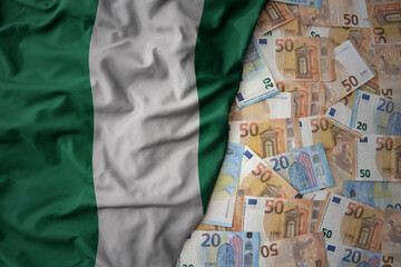 colorful waving national flag of nigeria on a euro money background. finance concept