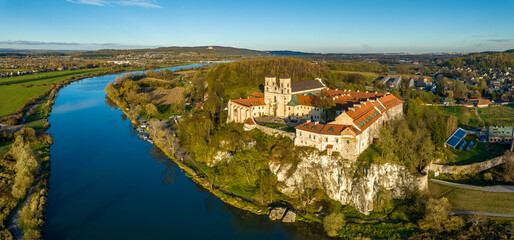 Tyniec near Krakow, Poland. Benedictine abbey and monastery on the rocky cliff and  Vistula River. Aerial wide panorama in autumn in sunset light