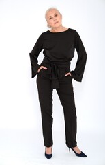 Aged mature woman in black suit on white background with smooth healthy skin face. Beautiful aging mature woman with blonde hair and happy smiling touching face. 
