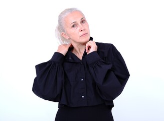 Aged mature woman in black suit on white background with smooth healthy skin face. Beautiful aging mature woman with blonde hair and happy smiling touching face. 