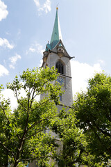 Fototapeta na wymiar Bell tower of Predigerkirche Church among the trees, Zurich, Switzerland.
