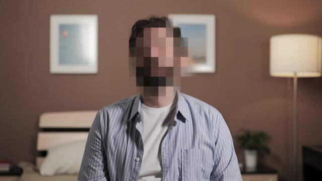 Hidden identity, hidden face, unknown person, silhouette interview. Man talks to camera or to interviewer, his face is hidden