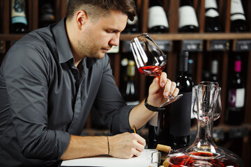Sommelier degustating red wine poured in glass