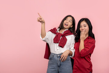 Surprised Asian woman wearing a red shirt and jeans covers her mouth with her hand. Young woman...