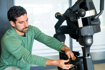 Mechanical exoskeleton engineer checking the mechanisms before the arrival of patients....