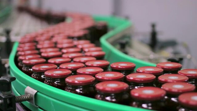 food jars canned bottles across the conveyor belt in a jam factory