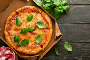 Margarita pizza. Traditional neapolitan margarita pizza and cooking ingredients tomatoes basil on wooden table backgrounds. Italian Traditional food. Top view. Mock up.