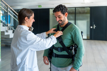 Obraz premium Mechanical exoskeleton, female physiotherapist doctor putting tapes on disabled person with robotic skeleton, physiotherapy in a modern hospital, futuristic physiotherapy