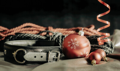 bdsm still life leather collar and christmas balls on silver fabric