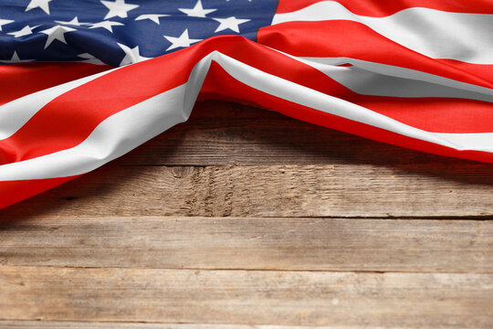 American flag on a rustic wooden background, copy space. Symbol of independence, patriotism.